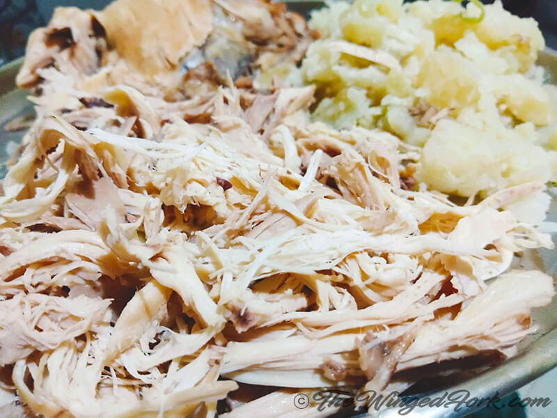 Shredded chicken and roughly mash potatoes in a plate
