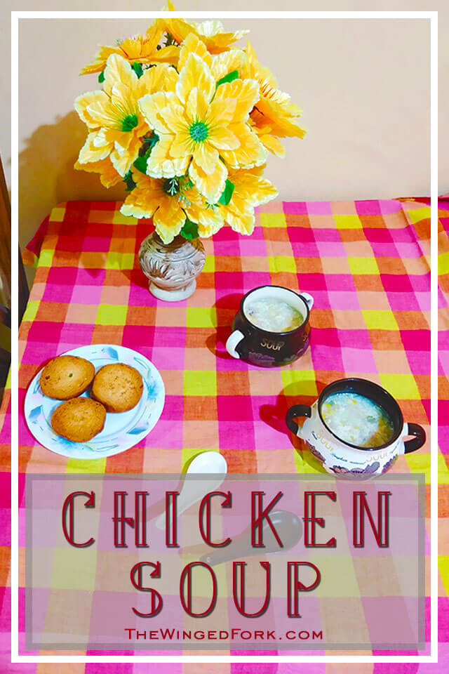 Pinterest image of chicken soup in two bowls on a table next to toast and a flower vase