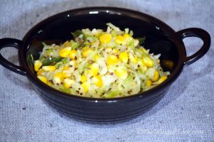 Corn and cabbage sabzi (veggies) in a black pot.
