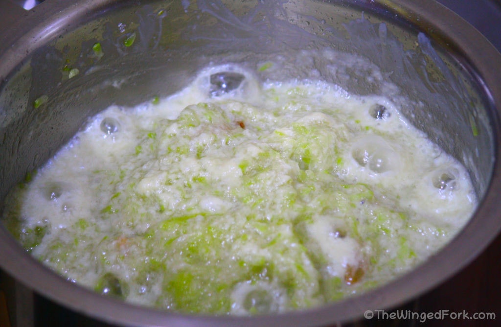 Milk cream, bottle gourd, sugar and cardamom boiling on the stove.