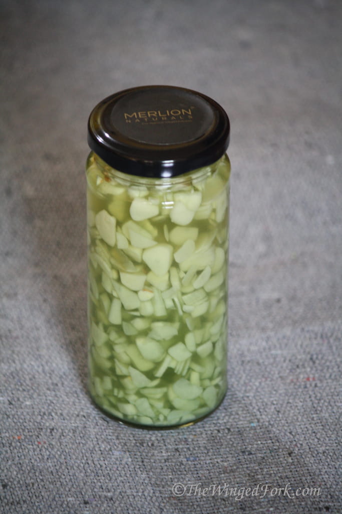 Pickled garlic sirka in a bottle.