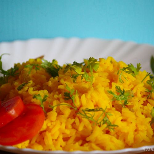 Rice served with coriander and tomatoes.