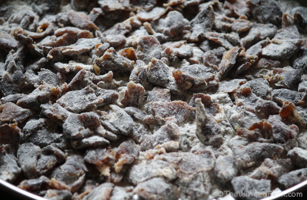 Pieces of dates coated in maida in a steel plate.