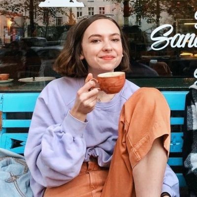 Picture of girl on a bench with a cup of coffee.