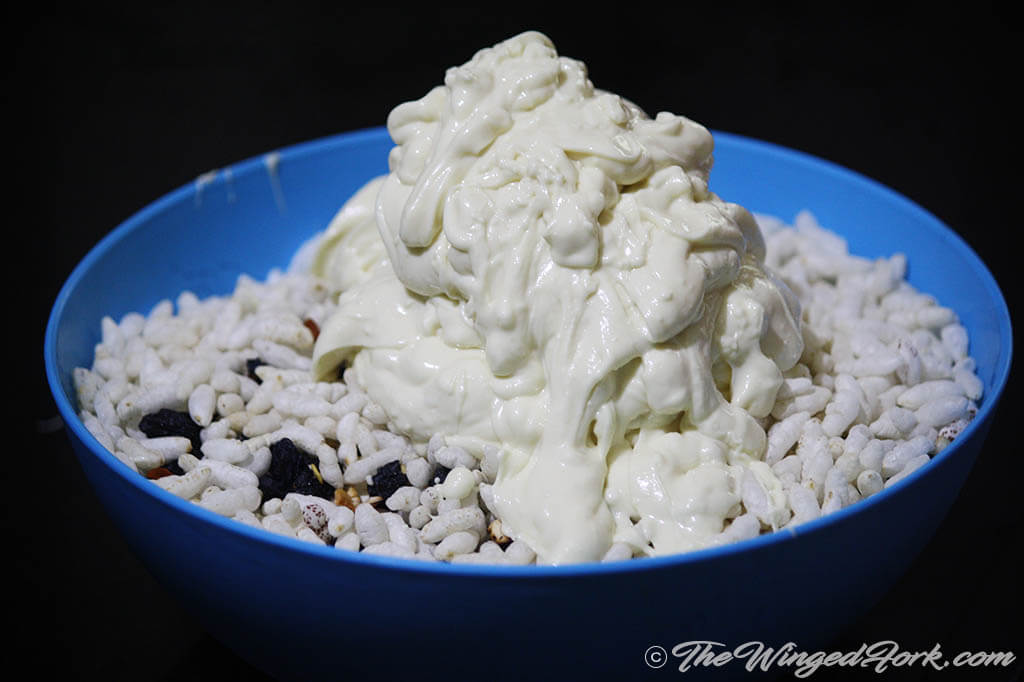 Pour the liquidized white chocolate over the mamra and dryfruits mix.