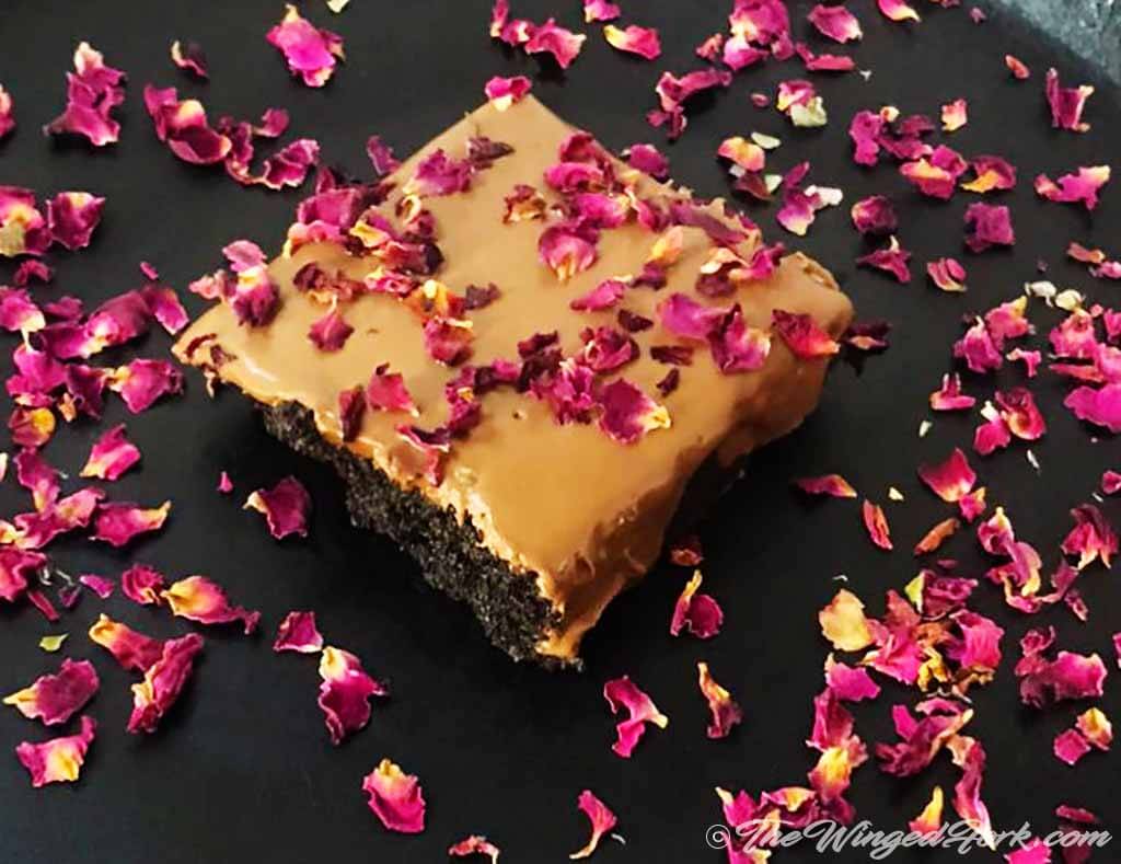 Chocolate brownie decorated with rose petals and served.
