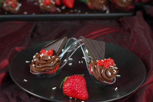 Chocolate Avocado mousse and strawberries served on a spoon.
