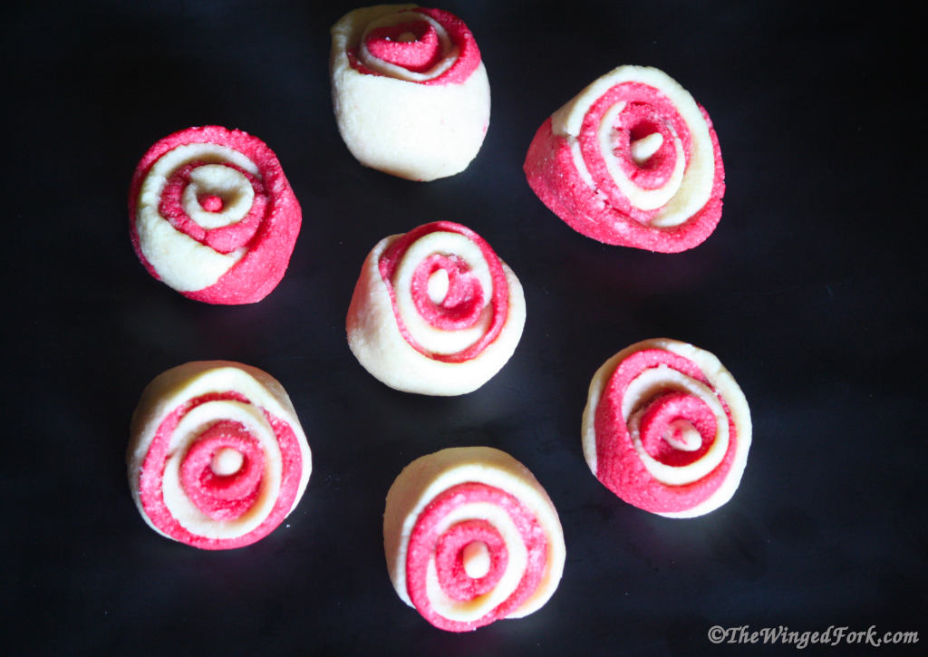 Pink and white valentines day cookies shaped like roses.