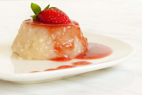 Tapioca Pudding with strawberry puree served on a white plate.
