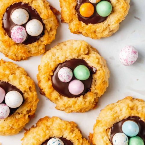 Cookies shaped like nest with chocolate and candies.