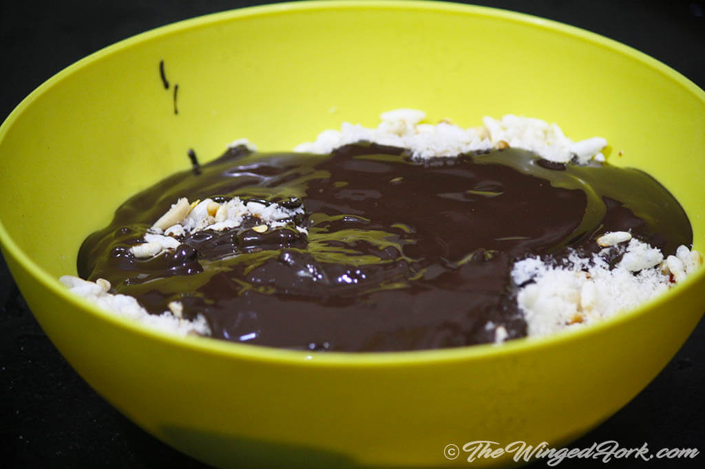 Mix roasted kurmuri, desiccated coconut and melted chocolate.