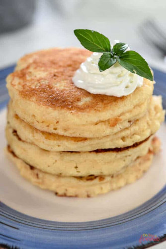 Keto sourdough pancakes over each other topped with a dollop of cream.