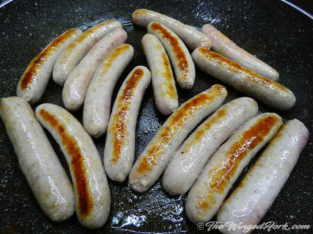 Sausages shallow frying in oil.