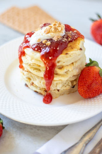 Strawberry cheesecake pancakes on a white plate.