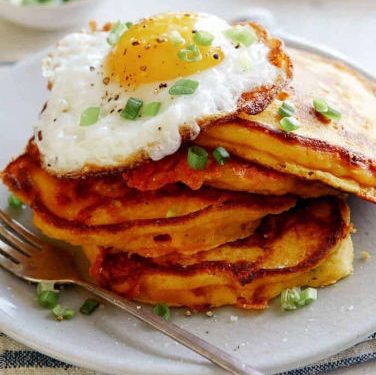 Cheesy Pumpkin Pancakes topped with eggs.