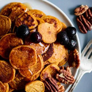 Sourdough Pumpkin Pancake cereal in a plate with pecans and berries.