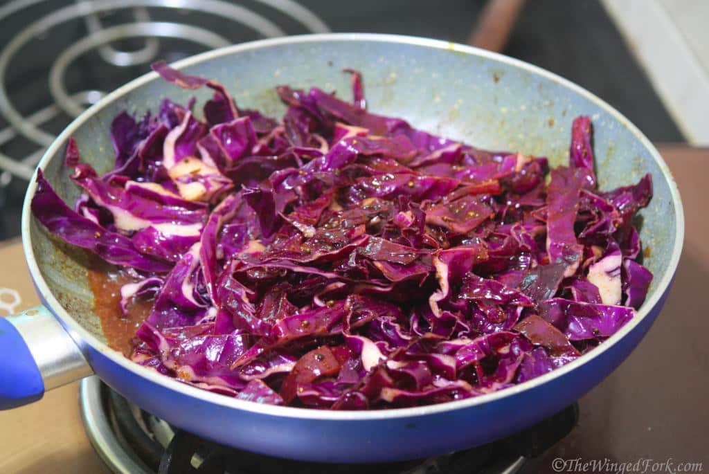 Soy sauce and pepper powder added to a frying pan with cabbage.