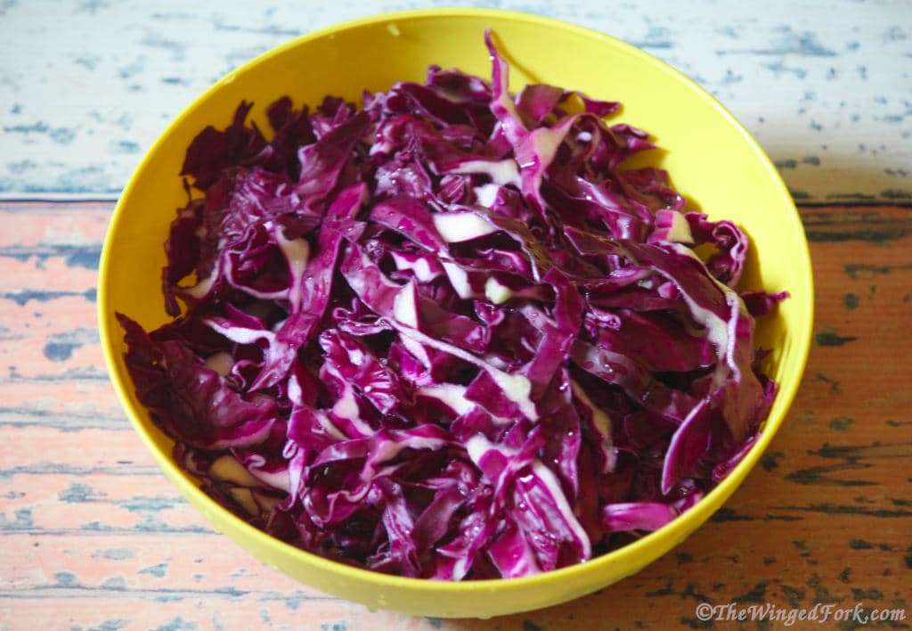 Cut purple cabbage in a yellow bowl.