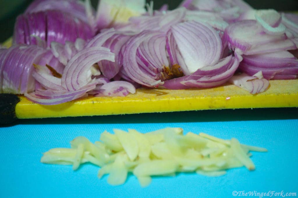 Sliced onions and garlic on chopping boards.