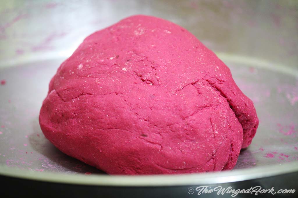 Pink Beetroot dough is kneaded on a plate.