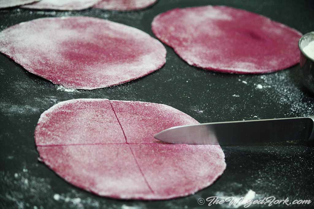 Pink round chapatis cut into 4 parts with knife.