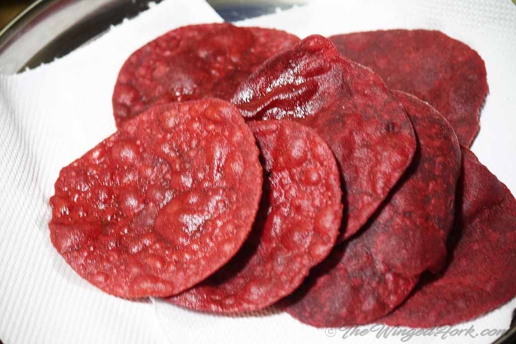 Fried beetroot puri placed on the tissue to drain oil.