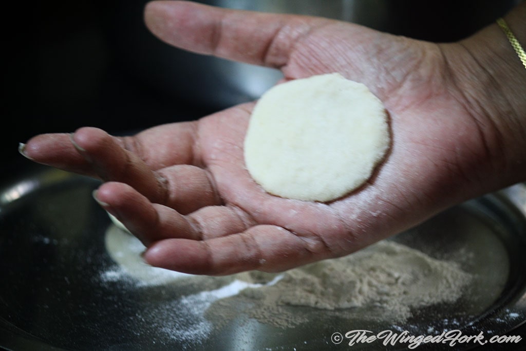 Flat dough ball in a hand.