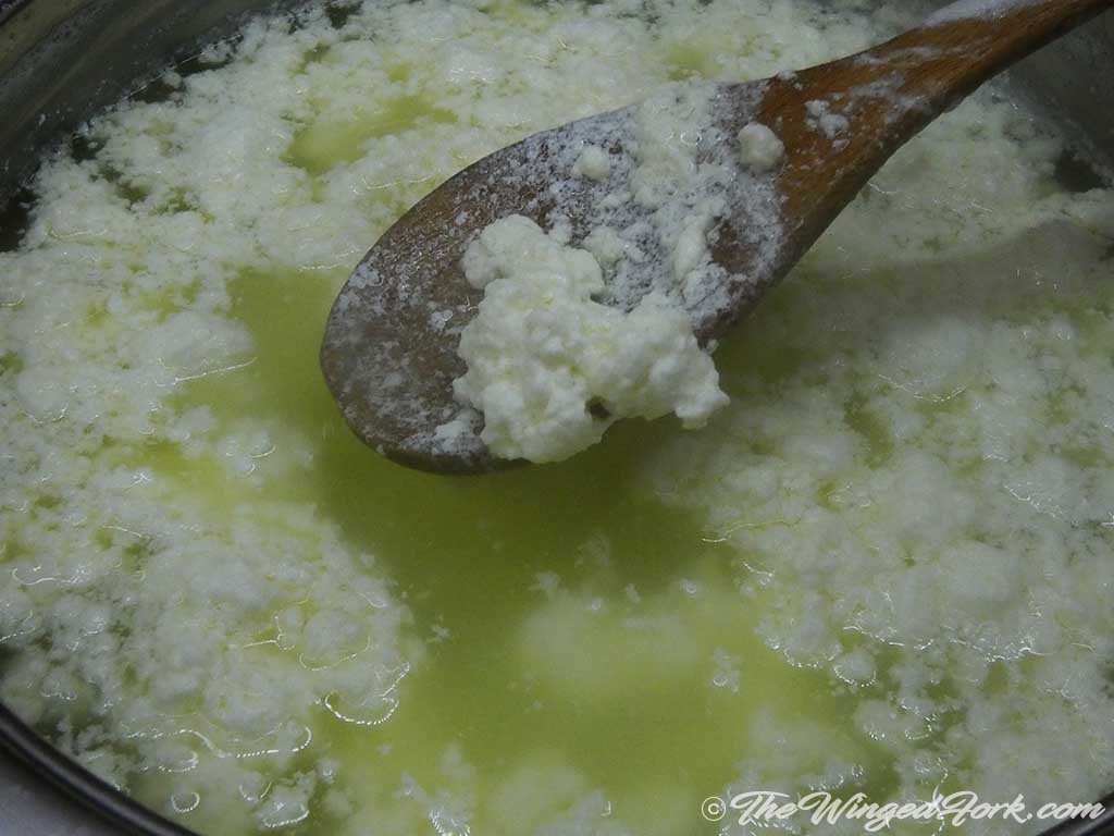 Lumps of curd and whey separated.