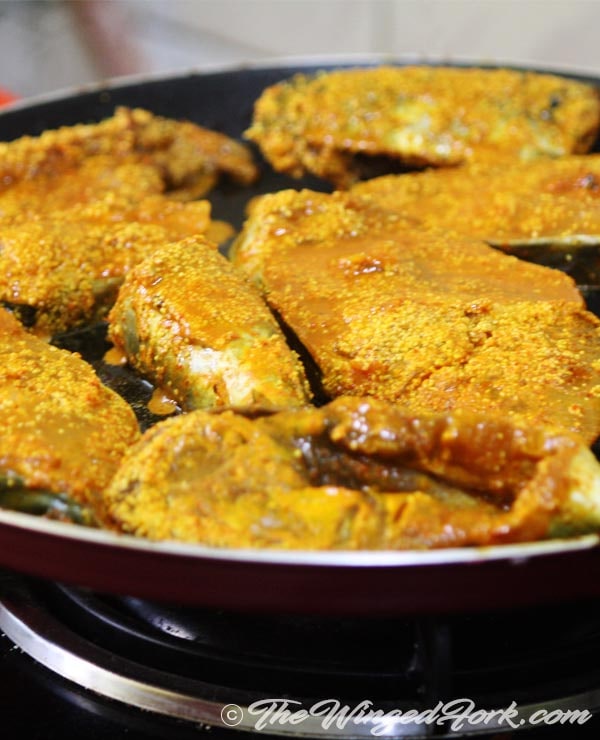 Oil fry the marinated surmai in a shallow pan.