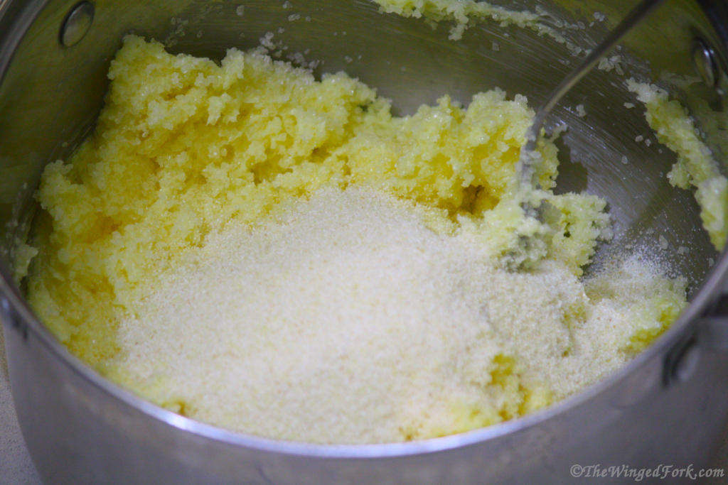 Semolina added to a mixture of butter and sugar in a vessel.