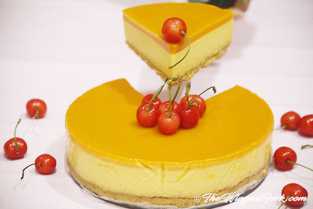 A big slice of veg mango cheesecake topped with cherries.
