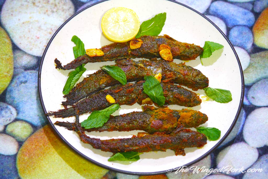 Fried Mudskippers on a plate garnished with mint and a lime.