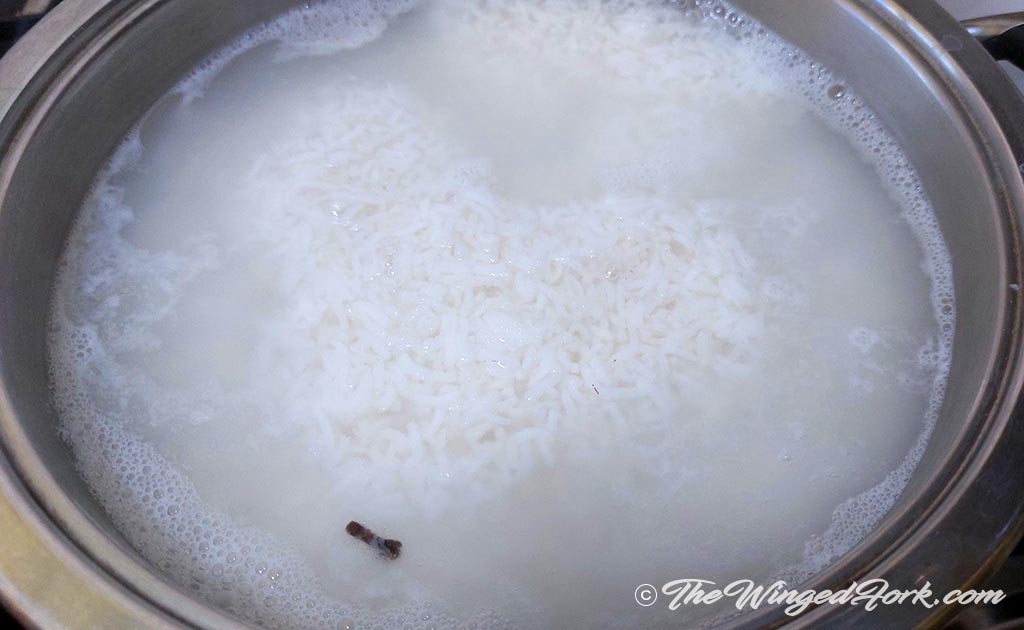 Rice boiling in water with clove.