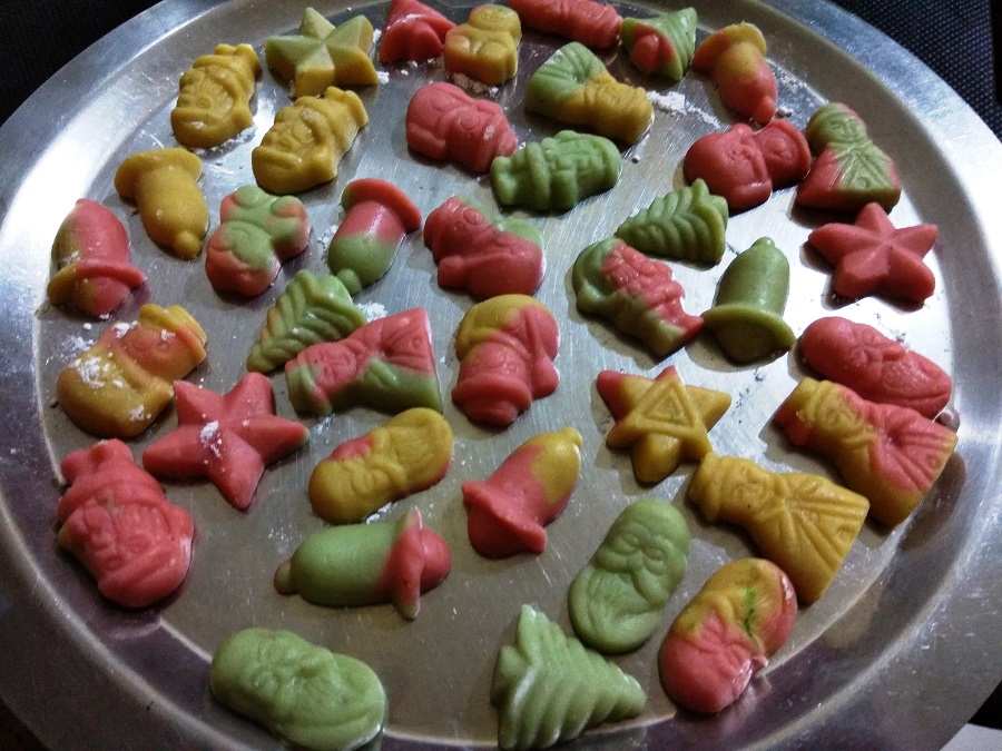 Angels, stars, santa, bells and tree shaped Marzipan on a steel tray.