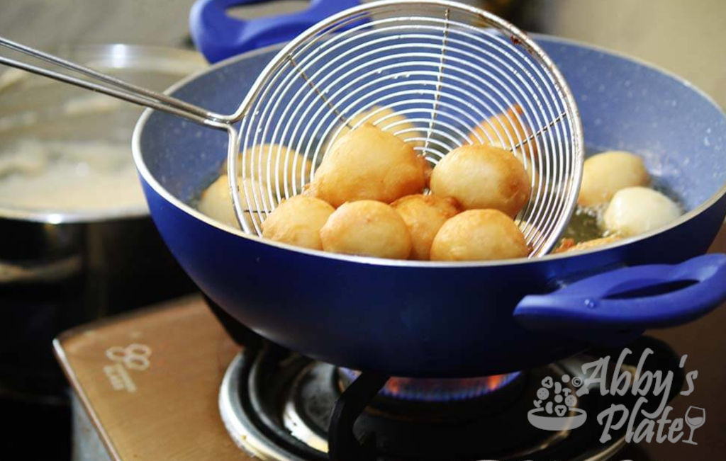 East Indian balloon bread in a sieve and frying pan.