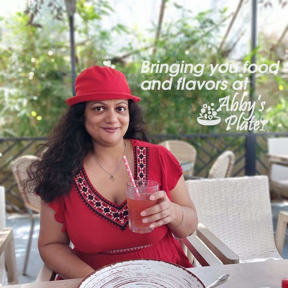 Pic of food blogger Abby of AbbysPlate in a red dress holding a watermelon juice.