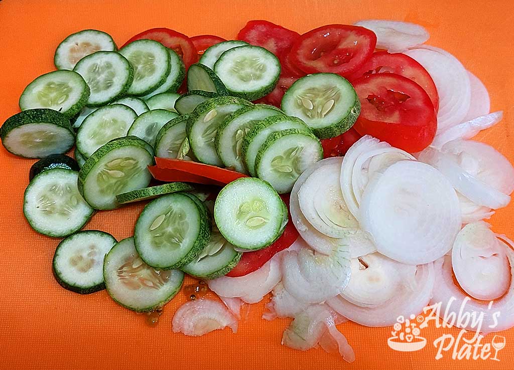Cucumbers, onions and tomatoes cut in rings.