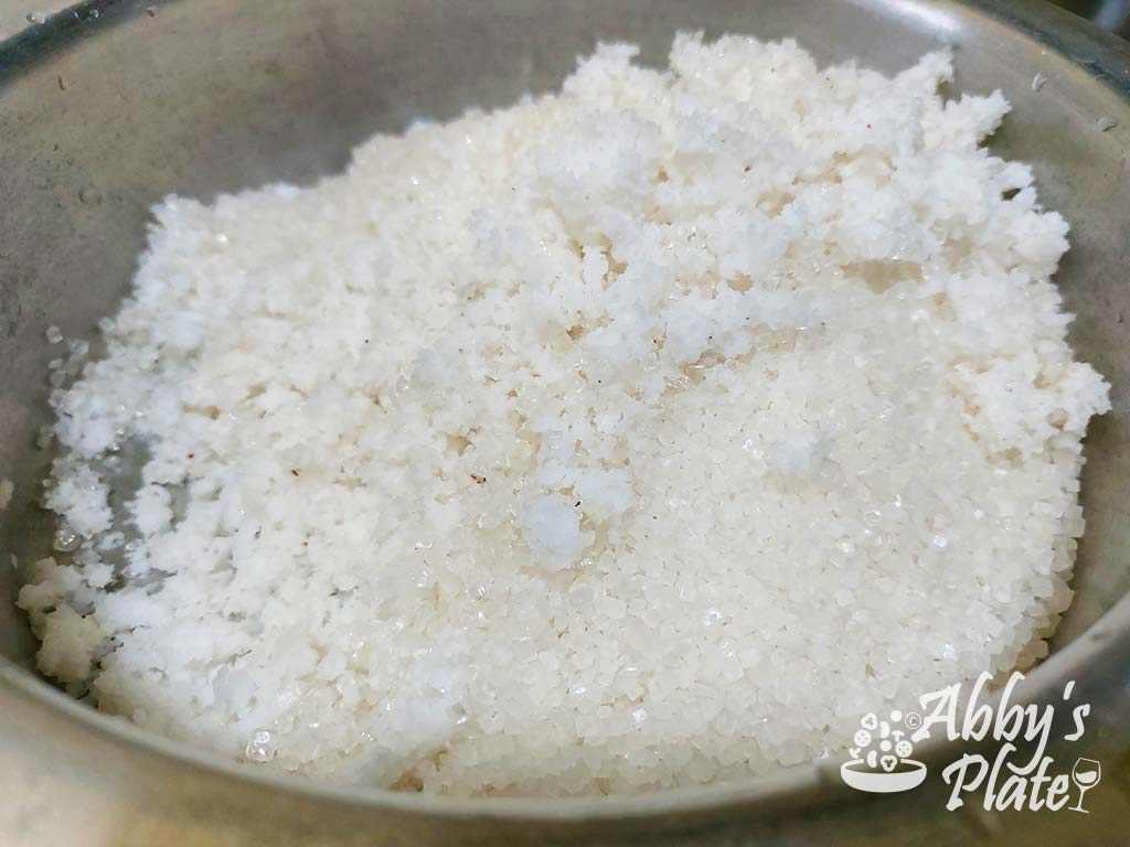 Grated coconut and sugar in a pot.